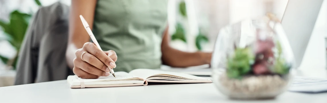 Woman holding a pen with a notebook